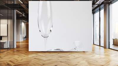 Two champagne glasses, one fell. Vertical image, clear wine glasses. Wall mural