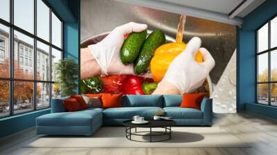 Yellow bell bepper and cucumbers washing by tap water. Vegetables in a kitchen sink. Wall mural