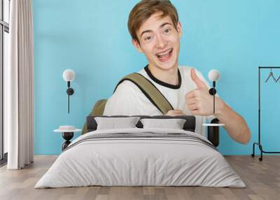 young funny male teenager in white t-shirt on blue background with bag Wall mural