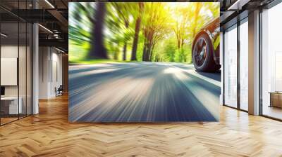 Car driving on a forest road. Motion blur of a car driving through a lush green forest, focusing on the wheel and the road Wall mural