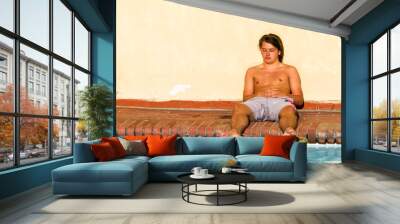 Young man relaxing at the pool on vacation Wall mural