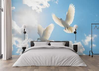 Two white doves fly in a bright blue sky with fluffy white clouds. Wall mural