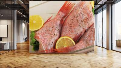 raw seabass stuffed with parsley and lemon in a glass dish on wo Wall mural