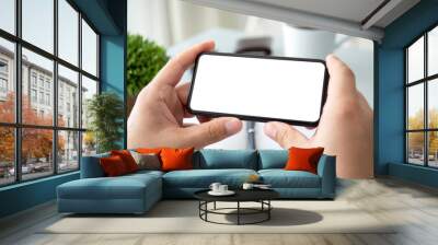 male hands holding horizontally phone with isolated screen in office Wall mural