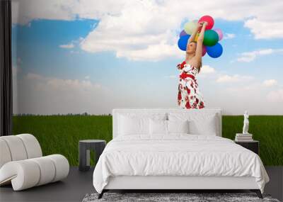 pretty girl playing with balloons in a field on holiday Wall mural