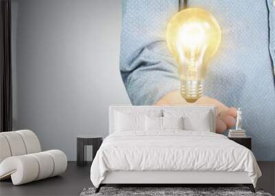 Hand of holding illuminated light bulb, innovation inspiration concept Wall mural