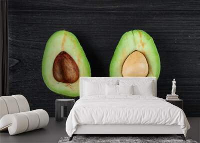 green avocado on black wooden background close-up Wall mural