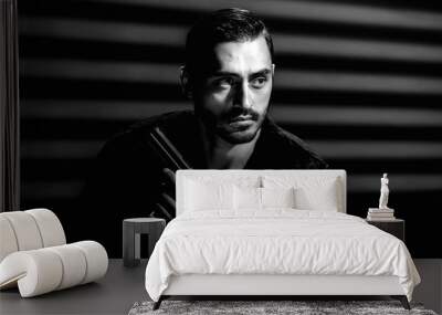 Black and white portrait of stylish handsome man posing with pistol Wall mural