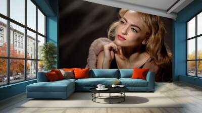 Young elegant retro woman posing with fur coat Wall mural