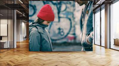 Young sad teen boy standing outdoors while man stranger scolding him Wall mural