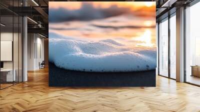 Sea foam washing up on the shore at sunset Wall mural