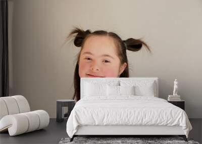 Cute smiling down syndrome girl on the grey background Wall mural