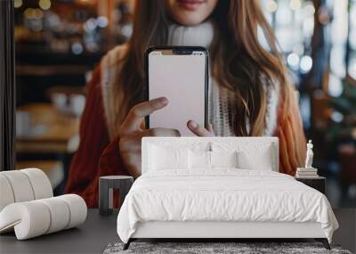 Mockup image of a beautiful woman pointing finger at a mobile phone with blank white screen Wall mural