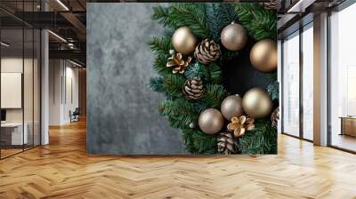 Closeup View of a Christmas Wreath with Gold Ornaments and Pinecones Against a Textured Gray Background Wall mural