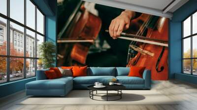 Symphony orchestra on stage, hands playing cello. Shallow depth of field, vintage style. Wall mural