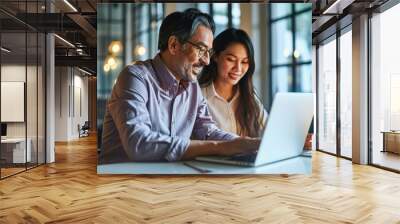 Two happy diverse professional colleagues Latin business man and Asian woman corporate executives working together in office using laptop, talking, Generative AI Wall mural