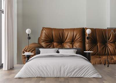 A sophisticated brown leather sofa with buttoned seating, against a plain white backdrop.
 Wall mural