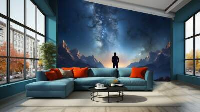 A man standing on top of a mountain under a night sky Wall mural