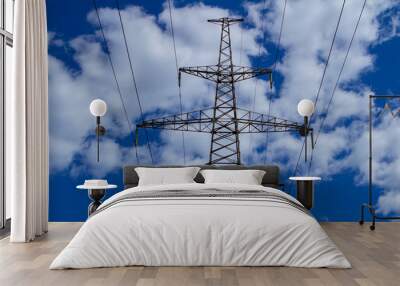 Electric high voltage tower with electric line against clouds blue sky Wall mural