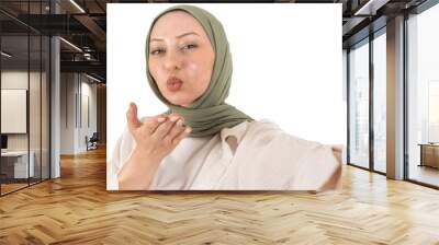 Blowing air kiss, close up young caucasian muslim woman blowing air kiss. Selective focus. Isolated transparent png. Teen girl in green hijab studio photo. Islam religious lady lifestyle concept idea. Wall mural