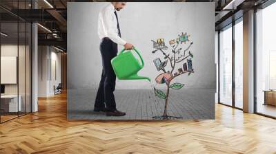 Businessman watering a plants with graph and stats Wall mural