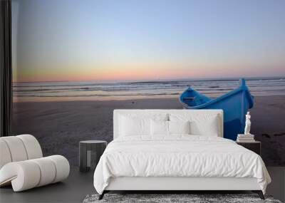 Sunrise on beach and blue boat Wall mural