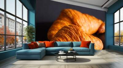 two crunchy delicious croissants at black background Wall mural