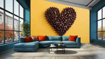 Heart or love shape coffee beans on vibrant yellow solid background, roasted brown caffeine bean warmth & artistic arrangement. top view Wall mural