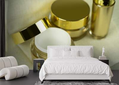 Mockup empty luxury golden two cream jars and bottle for skincare and beauty skin on brown fabric folds background. Wall mural