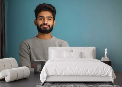 desi young man, attractive and happy, wearing a sweatshirt in the cold and staring at a copy space on camera Wall mural