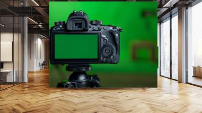 Isolated against a green background, the DSLR camera is on a tripod with an empty screen. The green screen chromakey Wall mural