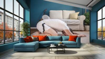 Man practice yoga at home Wall mural