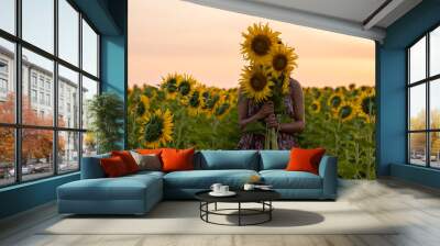 Happy young girl with sunflower at filed flower sunrise time. Wall mural