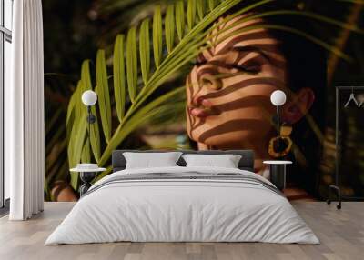 Portrait of a beautiful tropical girl with a palm tree leaf on her face. Organic. Spa Wall mural