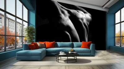 Male fitness model showing muscles in studio with a black backgr Wall mural