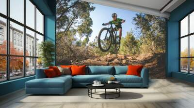 Wide angle view of a mountain biker speeding downhill on a mountain bike track in the woods Wall mural