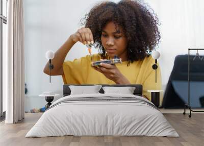 Happy cheerful American - African black ethnicity female university student learning about robotic and programing by herself, woman assemble a robot. Wall mural