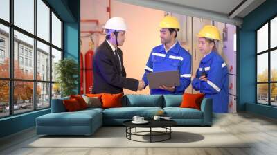 Professional electrical engineer team using laptop computer to inspecting the electrical circuit in control room. Wall mural