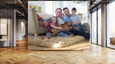 same sex male couple sitting on the floor in their living room with their son and daughter. their pe Wall mural