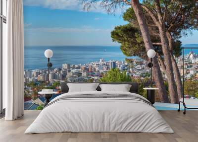 A blue pool on a luxury property with a coastal view of Cape Town and tourist landscape. The ocean and city against a clear sky horizon. A popular travel destination for tourists in South Africa Wall mural