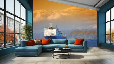 Ship, ocean and mountain at sunset to travel with clouds, water and transportation for vacation sailing. Cruise, sky and sea with yacht for tourism, holiday and adventure with sunrise, trip or nature Wall mural