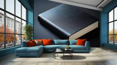 black closed book with blank cover over black background Wall mural