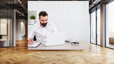 cheerful bearded businessman or student using laptop Wall mural