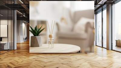 close up of reed diffuser and house plant aloe vera on wooden table in bright living room Wall mural