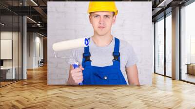 portrait of young man painter in workwear with roller paintbrush Wall mural