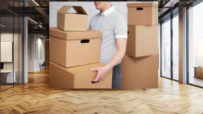 postal delivery or moving day concept - close up of a man holding many boxes during move Wall mural