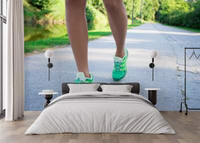 runner woman feet running on road in park Wall mural