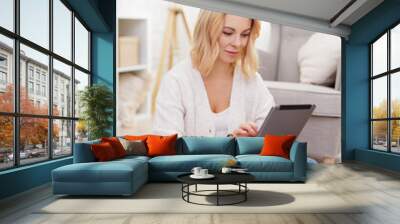 young beautiful woman using tablet pc in living room Wall mural