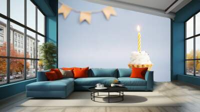 cake with yellow candle on a blue background Wall mural