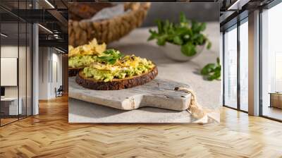 Avocado and egg sandwich with whole grain brown bread and greens, healthy diet vegan food. Breakfast on wooden board, white table. Copy space. Wall mural